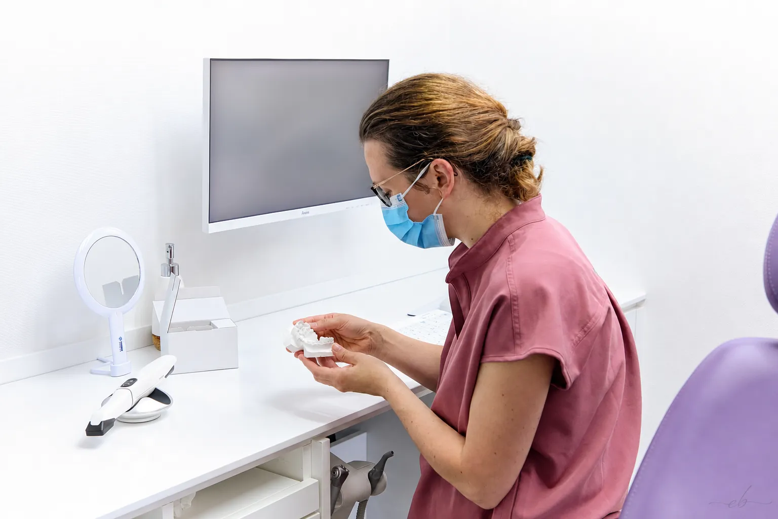 Orthodontiste présentant un modèle dentaire en consultation